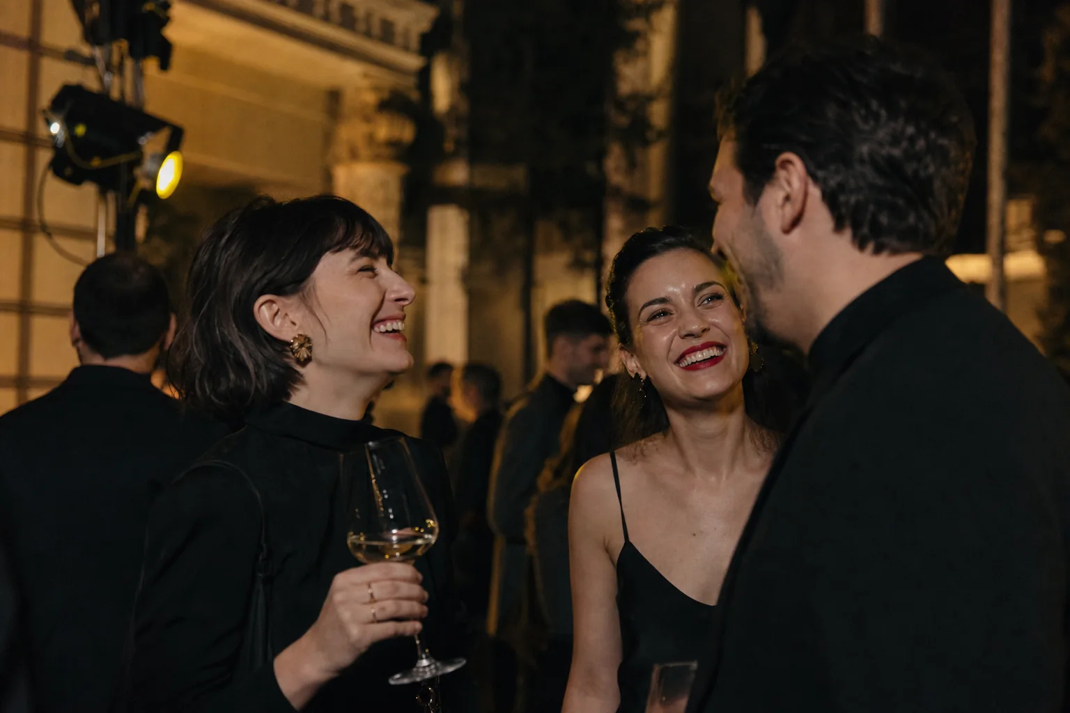 Două invitate râzând împreună după un moment reușit al serii